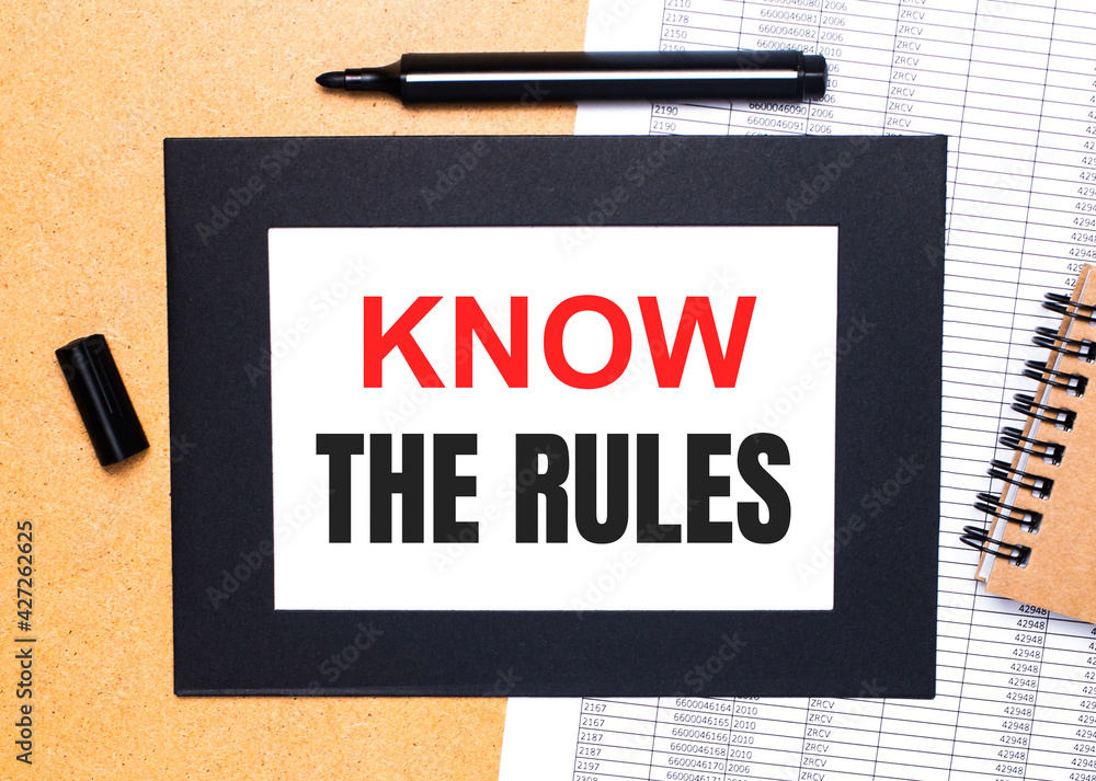 Poster on a wooden table, there is a black open marker, a brown notepad and a sheet of paper in a black fra