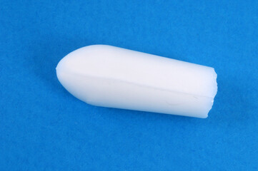 Concept de constipation un suppositoire sur fond bleu