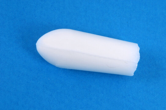 Concept de constipation un suppositoire sur fond bleu