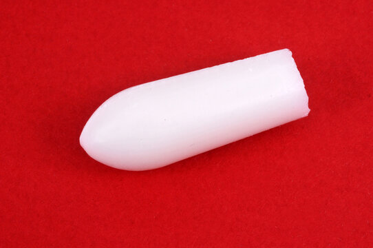 Concept de constipation un suppositoire sur fond rouge