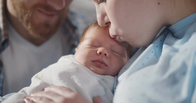 Close Up Portrait Of Woman And Man Holding Newborn Baby