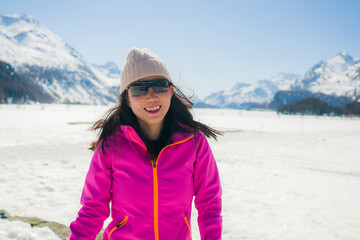 winter outdoors lifestyle portrait of young happy and attractive Asian Korean woman enjoying playful on snow at beautiful alpine mountain during Christmas holiday