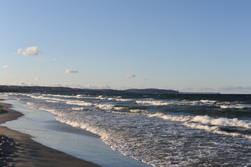 Turquoise sea water waves with horizon and blue sky on a sunny day at the seaside coast of Baltic...