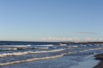 Turquoise sea water waves with horizon and blue sky on a sunny day at the seaside coast of Baltic...