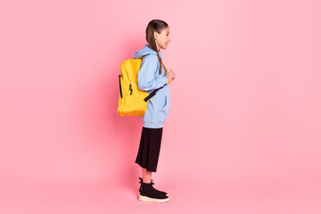 Full length body size profile side view of pretty cheerful girl ready to school isolated over pink pastel color background