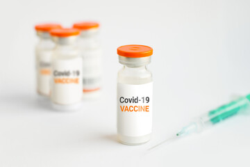 Vaccine against covid 19. Several jars with coronavirus vaccine and a syringe on a white background