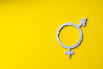 Gender equality symbol in silver color on yellow background, copy-space