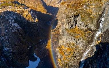 Norwegian Voringfossen waterfall in early spring, leftover ice left over from winter in the Mabodalen valley in the Eidfjord municipality.