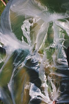 Huge plastic waste bag on natural green background symbolising garbage and climate change 