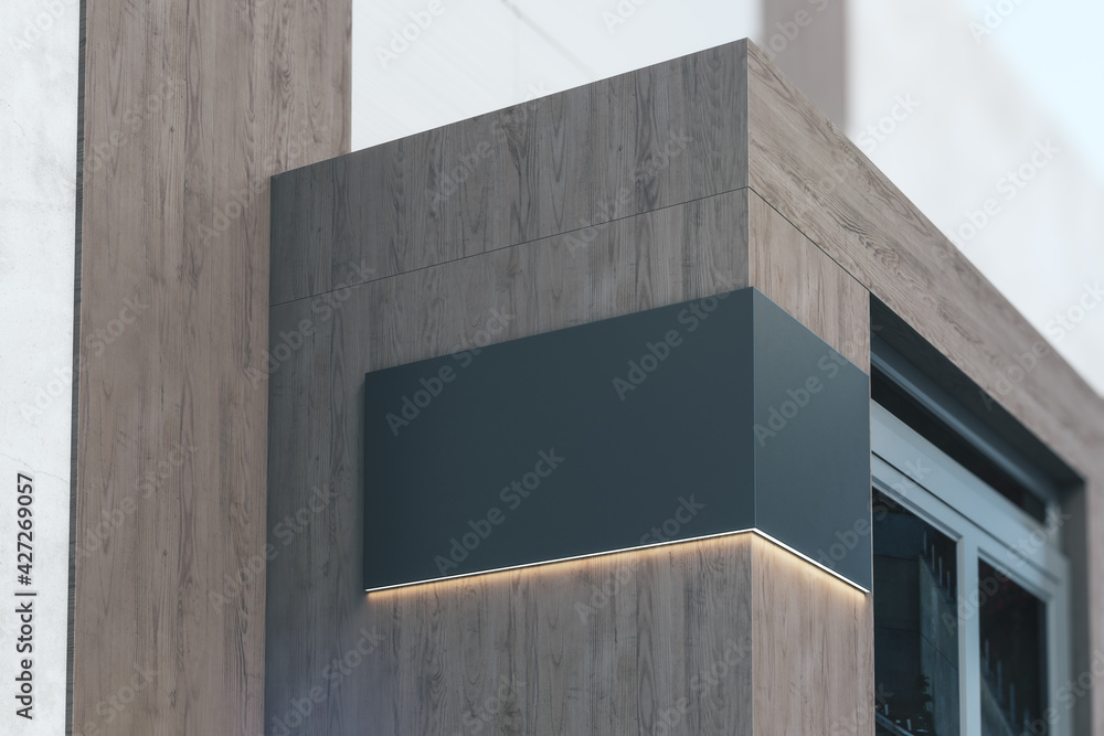 Poster black signboard with copyspace and backlight on the corner of eco style wooden building near entranc