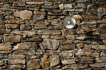 Old street light lamp on stone wall background. 