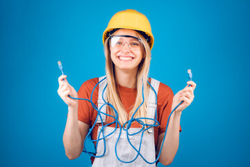 A beautiful young woman, communications engineer, is holding the two ends of an Ethernet cable. Communicate about internet connections, engineering, professionals in the telecommunications business.