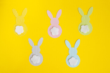 easter paper bunnys isolated on yellow background, concept: childrens crafts for Easter, top view
