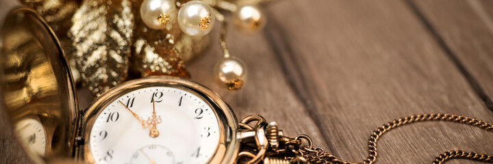 Fototapeta na wymiar Vintage pocket clock showing five to twelve and golden decoratio