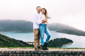 Couple hugging and enjoying the breathtaking panorama of the Azores, Portugal.