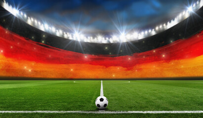 Ball on the green field in soccer stadium with German flag on the background. ready for game in the...