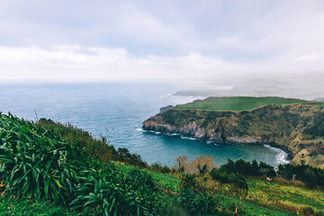 Lonely beautiful viewpoint overlooking the sea and the lush nature of the Azores.