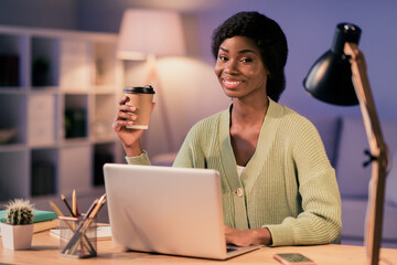 Portrait of attractive cheerful girl studing late evening web remote education drinking caffeine in flat house living-room indoor