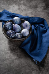the concept of ways of coloring organic eggs for Easter with natural dyes. Marble eggs painted blue with blueberries