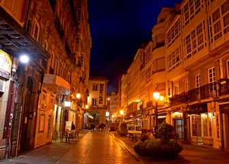Fototapeta na wymiar Imagen nocturna de una calle peatonal en verano con la atmósfera cálida que le confiere la iluminación artificial
