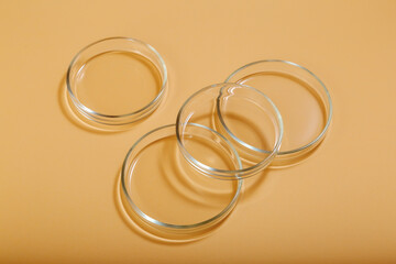 Clean empty petri dishes on beige nude background. Laboratory glassware for bio science, organic skin care products, cosmetic research. Cosmetic research circles