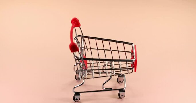 Shopping cart .Shop trolley.Safe online shopping concept. Light pastel background. Super slow motion