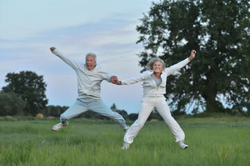 Fototapeta na wymiar happy senior couple jumping in the park