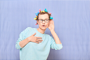 Girl with colorful hair curlers on head is eavesdropping conversation