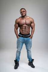 African American bodybuilder man, naked muscular torso, wearing jeans, isolated on white background