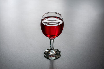 Glass of red wine on a dark background.