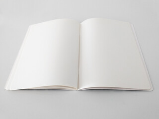 Perspective view of open and blank notepad isolated on white background. Aerial view of notebook to...