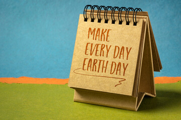 make everyday earth day inspirational note - handwriting in a small desktop calendar against abstract paper landscape, environmental concept