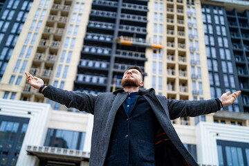 Excited young businessman raised arms. Successful worker celebrating wining. Feeling of freedom and...