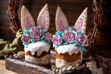 easter cake with rabbit ears made of gingerbread and meringue roses on a dark background