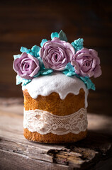easter cake decorated with roses meringue flowers on a dark background