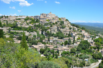 Fototapeta na wymiar Panoramic view of the medieval village of Gordes, Vaucluse, Provence-Alpes-Côte d’Azur, blue sky background. It is classified as one of the most beautiful villages in France.