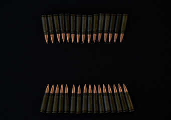 Cartridges for AKM 7.62x39 folded in a line on a black background