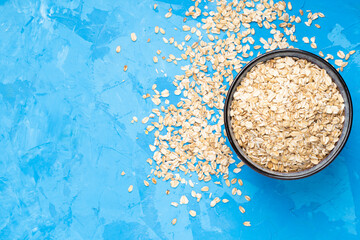 Oat flakes in a blue plate on a blue cement background