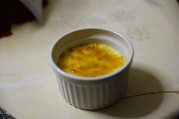 Creme Brulee in einer Schale mit Brenner beim karamellisieren 
