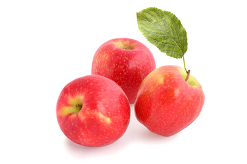 Three ripe red apples with leaf isolated on white