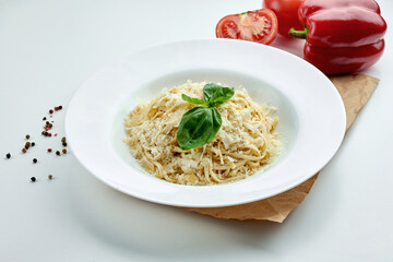 Classic Italian cheese pasta (spaghetti) with white sauce in a white plate on a white plate