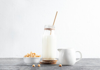 Alternative vegan milk of chickpeas in glass bottle with eco friendly straw on white background