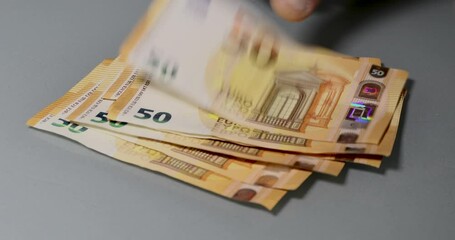 Manual counting of euro banknotes. Cash, 50 euro bills and 20 euro bills. - Powered by Adobe