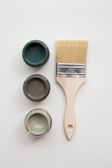 Overhead view of a DIY paint brush with trendy green sample paint pots