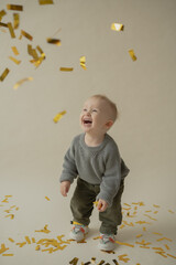 Little boy rejoice at the holiday. The boy has fun and throws some tinsel. Little kid has fun and enjoys the holiday
