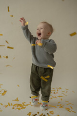 Little boy rejoice at the holiday. The boy has fun and throws some tinsel. Little kid has fun and enjoys the holiday