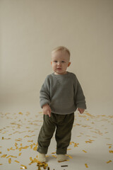 Little boy rejoice at the holiday. The boy has fun and throws some tinsel. Little kid has fun and enjoys the holiday