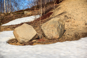 Two large stones near the melting snow