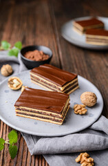 Cocoa and walnut cake with plum jam, topped with chocolate frosting