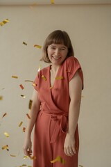 A young beautiful girl in a red overalls is dancing and throwing a bagura. Festive mood. Body positive